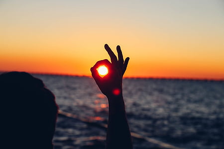 silhouette photo of person standing in front of body of water thumbnail