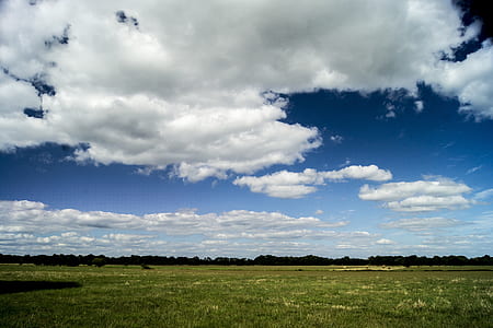 green field under white clouds thumbnail
