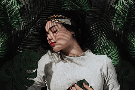 woman lying on green leaves photography thumbnail