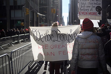 group of people rallying in street near buildings thumbnail