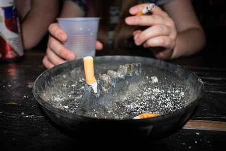 person smoking in front of an ashtray thumbnail
