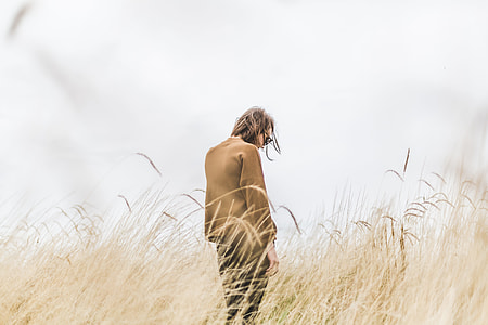 woman wearing brown top standing near brown grass at daytime thumbnail