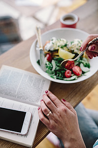 Woman eating breakfast and reading a book thumbnail