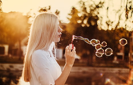 selective focus photography of woman blowing bubbles thumbnail