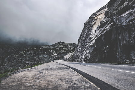 empty road beside rock formation during daytime thumbnail