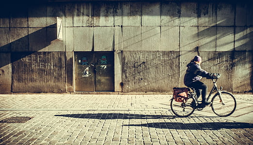 person riding on bicycle near building thumbnail