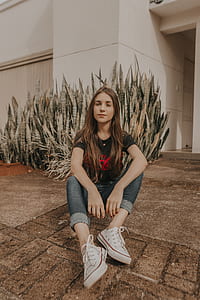 woman sitting on gray floor near snake plant thumbnail
