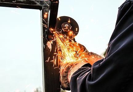 person grinding metal during daytime thumbnail