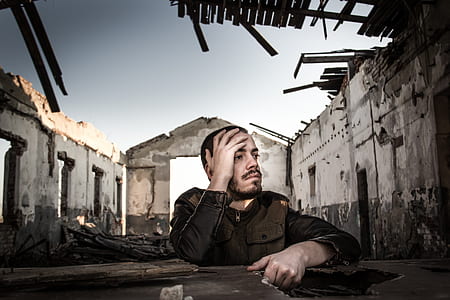 man sitting down with left hand on face thumbnail