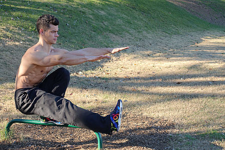 man doing balancing on green metal rod during day time thumbnail