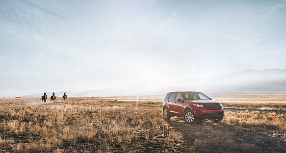 red Land Rover Range Rover parked on brown grass field thumbnail