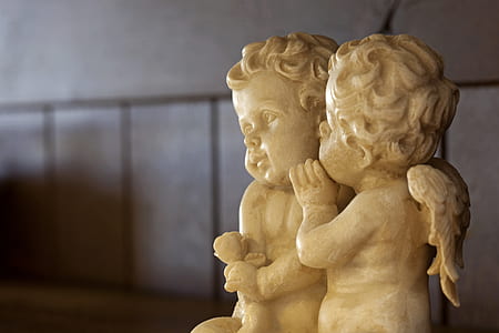 tilt shift lens photography of two cherub ceramic figurine thumbnail