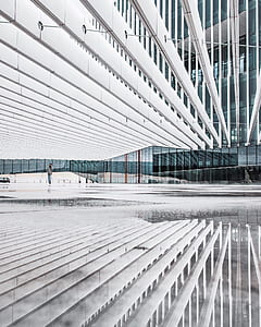 person in grey long-sleeved shirt walking near curtain building thumbnail