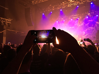 person taking picture at stage with multicolored lights thumbnail