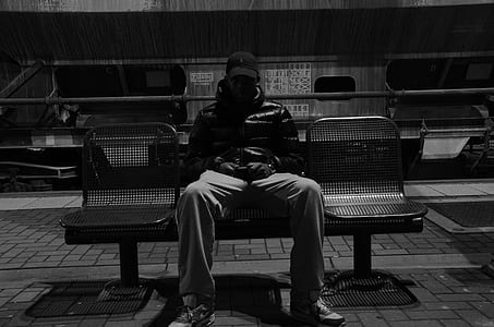 grayscale photo of man sitting in gang chair thumbnail