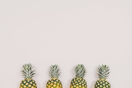 yellow-and-green pineapple fruits near white wall thumbnail