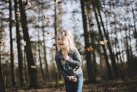 child playing in front of trees thumbnail