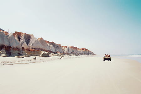 people riding truck in seashore thumbnail
