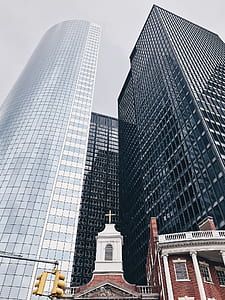 low angle photography of church and high-rise buildings thumbnail
