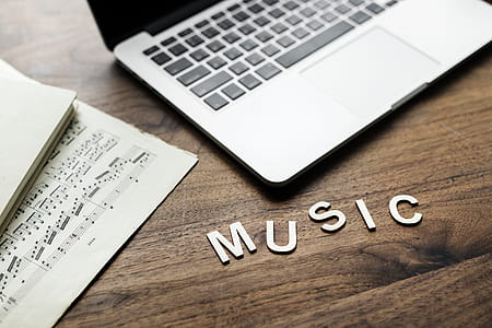 Music Cutout Letter Beside Macbook Pro on Table thumbnail