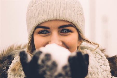 woman holding snow selective focus photography thumbnail