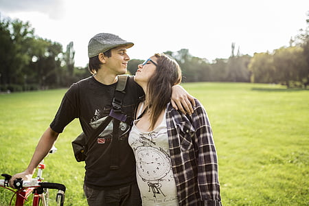 man and woman standing on green grass field at daytim,e thumbnail