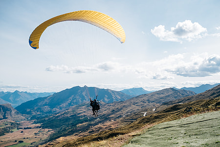 person on yellow parachute flying during daytime thumbnail