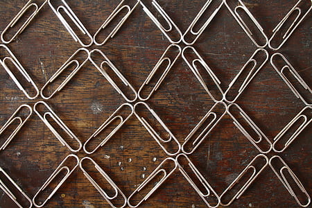 gray paper clips on brown wooden surface thumbnail