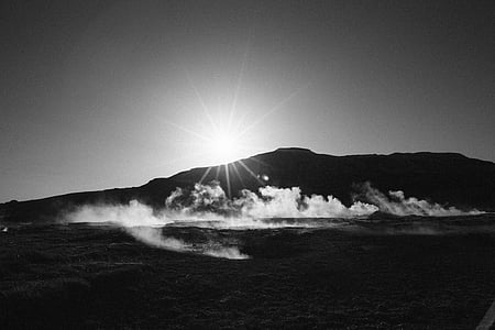 grayscale photography of body of water and mountains during daytime thumbnail