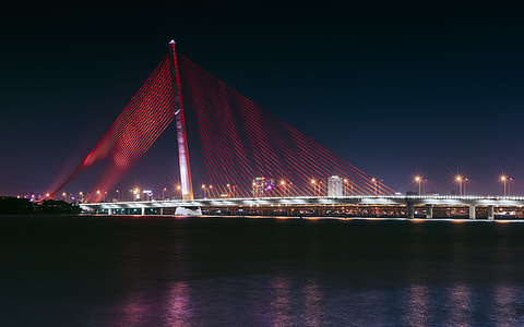 bridge with lights near body of water thumbnail