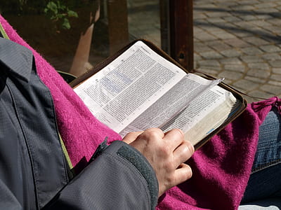 person wearing black top while reading book thumbnail