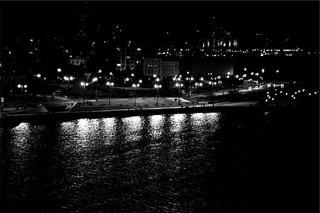 grayscale photo of street lights near body of water thumbnail