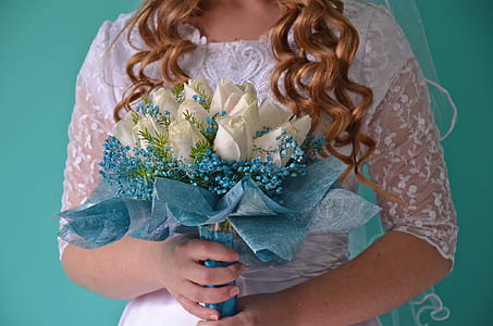 woman wearing white elbow-sleeved wedding dress holding white rose bouquet near green wall thumbnail
