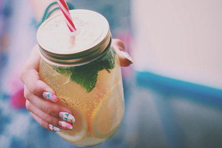 person holding glass jar with lid and straw thumbnail