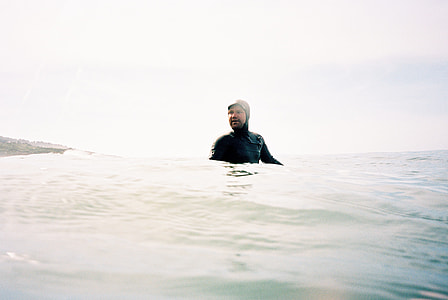man wearing wetsuit on chest-deep water thumbnail