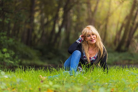 woman sits on grass field during day thumbnail