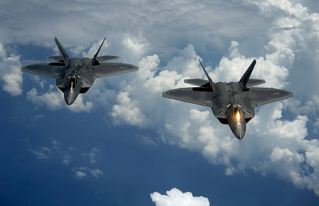 two gray aircrafts flying over clouds thumbnail