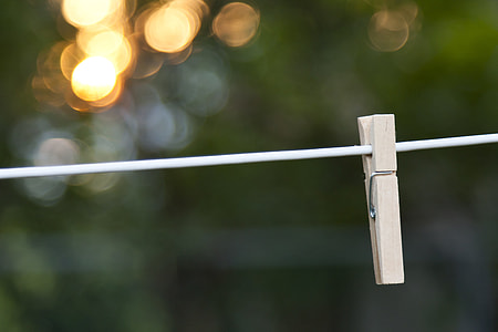 tilt shift photo of brown wooden clip on white string thumbnail