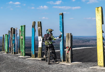 biker holding blue post overlooking land view screenshot thumbnail