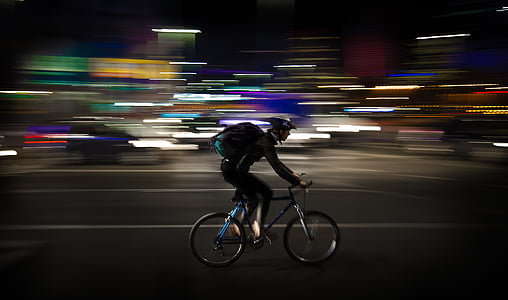 selective focus photography of person biking at night-time thumbnail