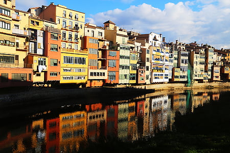 assorted-color concrete building near body of water thumbnail