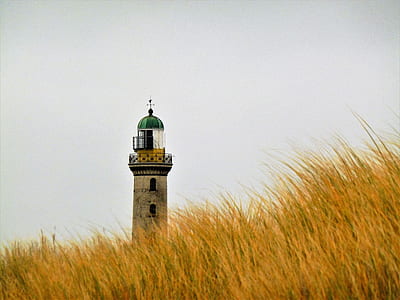lighthouse beside yellow grass field thumbnail