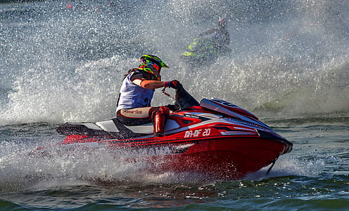 man riding red personal watercraft on water thumbnail