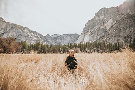 photography of boy surrounding grass during daytime thumbnail