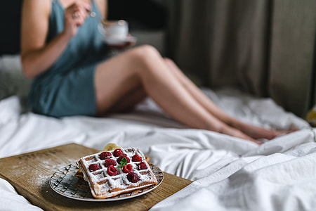 Breakfast in bed - waffles with raspberries and cup of coffee on the tray thumbnail