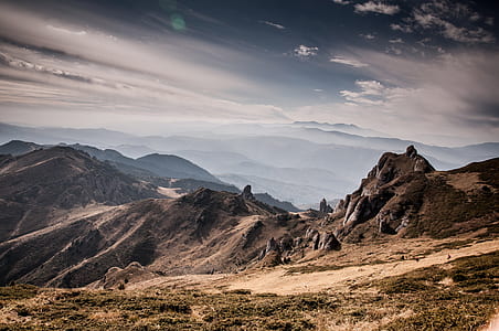 photo of mountains under cloudy sky thumbnail