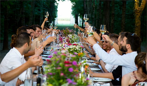 photograph of group of people toast of wine in front of table thumbnail