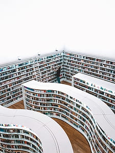man standing inside a library looking for a book thumbnail