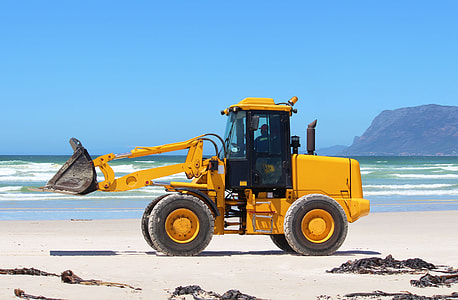 yellow and black excavator on brown sandy beach thumbnail