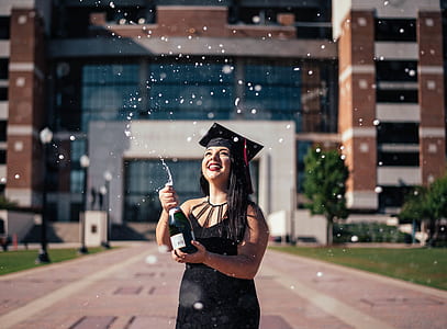 woman holding champagne bottle in front of building thumbnail